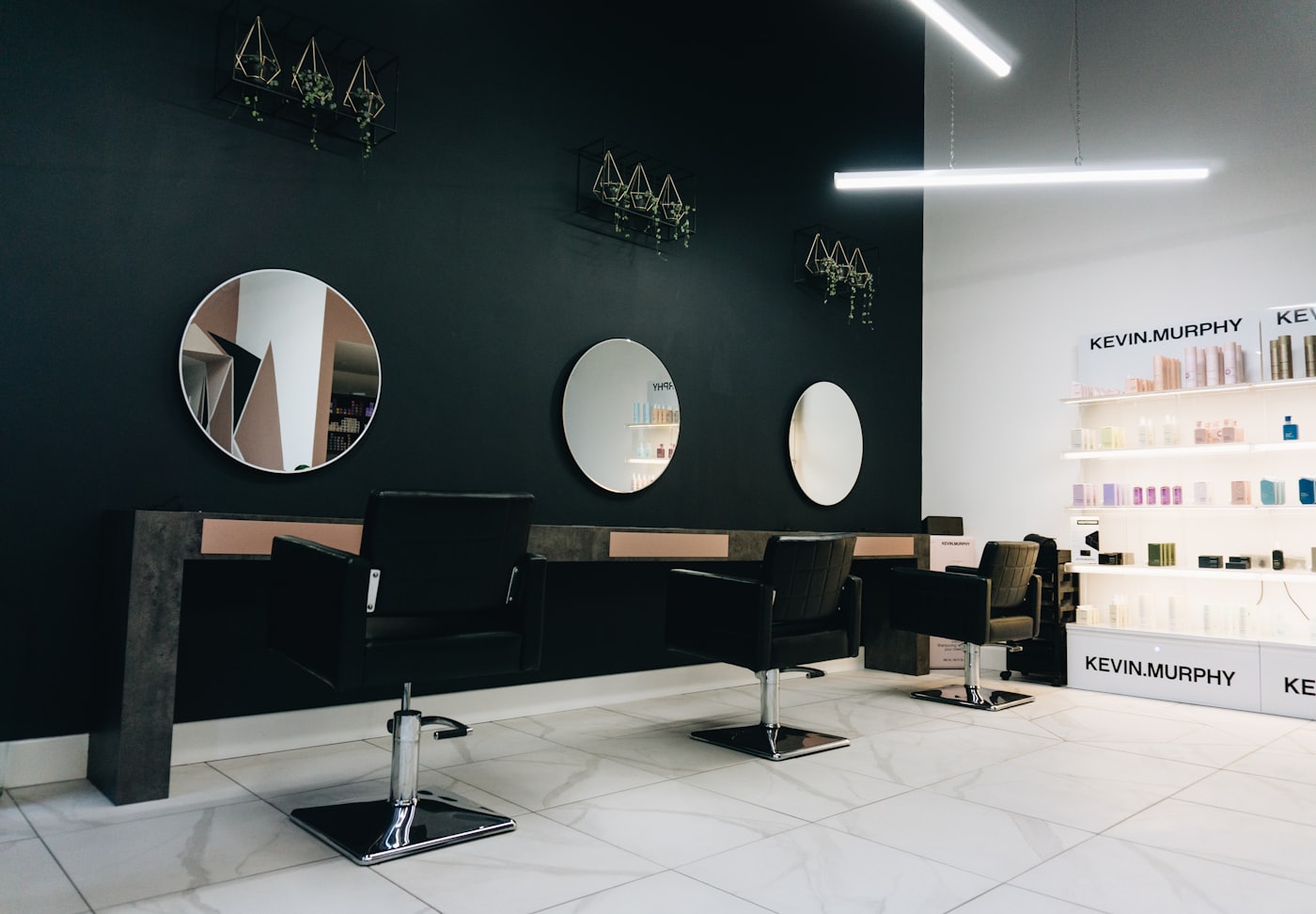 Inside Tinka Hair, styling stations along a mirrored wall