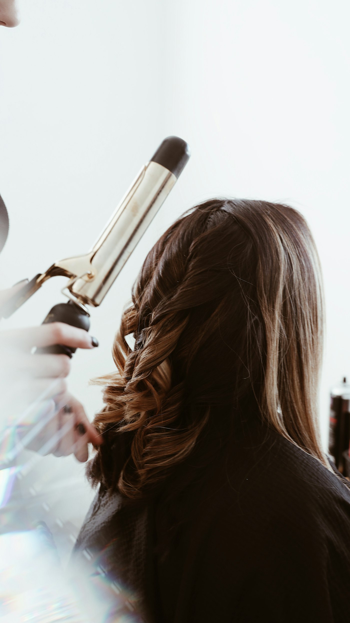 Freshly coloured hair being curled and styled at the mirror
